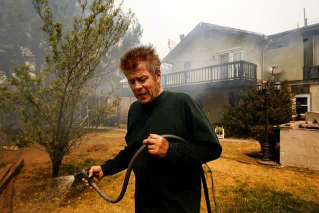 Richard Jenson tries to protect his home from the advancing wildfire in the mountains above Malibu on Friday. (Photo by Al Seib/Los Angeles Times)