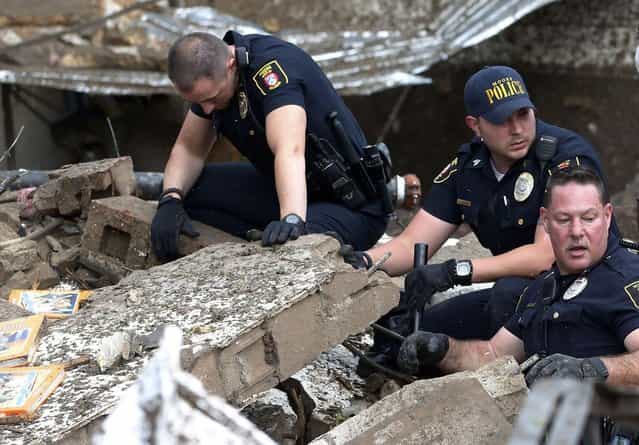 Moore police dig through the rubble of the Plaza Towers Elementary School following a tornado in Moore, Okla., Monday, May 20, 2013. (Photo by Sue Ogrocki/AP Photo)