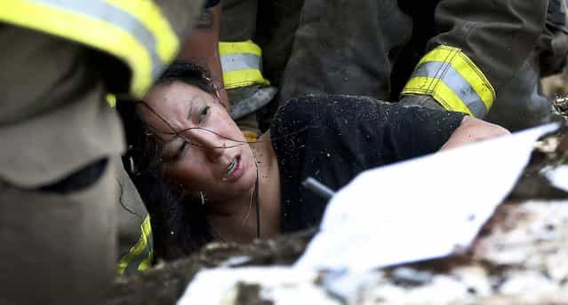 A woman is pulled out from under debris at the Plaza Towers School in Moore. (Photo by Sue Ogrocki/Associated Press)
