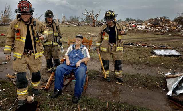 Oklahoma City firefighters check on the status of Gene Tripp as he sits in his rocking chair where his home once stood, in Oklahoma City. (Photo by Chris Landsberger/The Oklahoman)