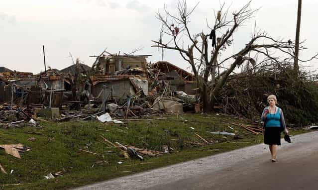 A woman walks near a destroyed home in Moore. (Photo by Steve Sisney/The Oklahoman)