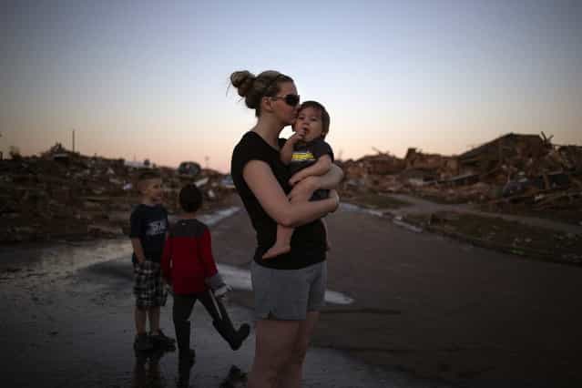 Rae Kittrell holds her son Rylan, who turned one-year-old today, a block away from her house in Moore, Oklahoma, two days after the Oklahoma City suburb was left devastated by a tornado on May 22, 2013. Kittrell's house survived the tornado. Tornado survivors thanked God, sturdy closets and luck in explaining how they lived through the colossal twister that devastated an Oklahoma town and killed 24 people, an astonishingly low toll given the extent of destruction. (Photo by Adrees Latif/Reuters)