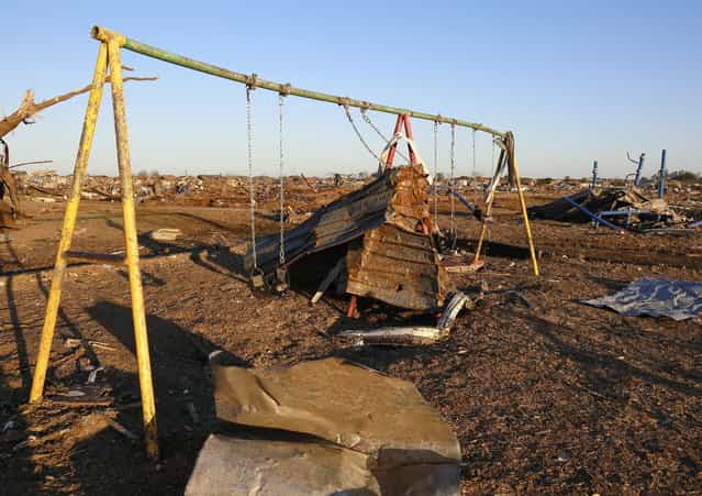 Debris is scattered around damaged playground equipment outside the Plaza Towers elementary school, where seven children died in a tornado, in Moore, Oklahoma May 22, 2013. Rescue workers with sniffer dogs picked through the ruins on Wednesday to ensure no survivors remained buried after a deadly tornado left thousands homeless and trying to salvage what was left of their belongings. (Photo by Rick Wilking/Reuters)