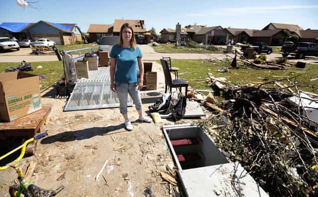 Jackie Watkins shows the storm shelter she and five members of her family survived the tornado May 22, 2013 in Moore, Oklahoma. The two-mile-wide Category 5 tornado touched down May 20 killing at least 24 people and leaving behind extensive damage to homes and businesses. U.S. President Barack Obama promised federal aid to supplement state and local recovery efforts. (Photo by Brett Deering/AFP Photo)