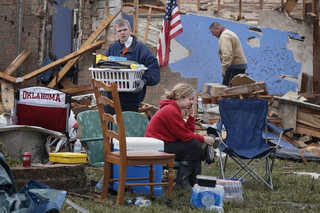 Resident Taylor Tennyson sits in the front yard as family members salvage the remains from their home which was left devastated by a tornado in Moore, Oklahoma, in the outskirts of Oklahoma City May 21, 2013. Rescuers went building to building in search of victims and thousands of survivors were homeless on Tuesday, a day after a massive tornado tore through a suburb of Oklahoma City, wiping out whole blocks of homes and killing at least 24 people. (Photo by Adrees Latif/Reuters)