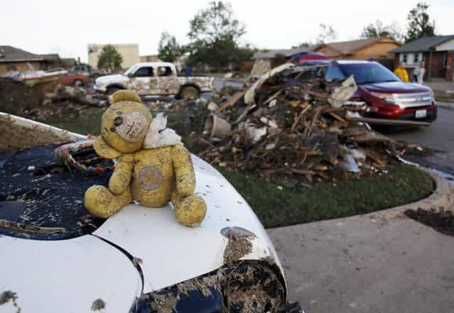 A teddy bear salvaged from the rubble of a tornado-destroyed home sits on the boot of a vehicle, in Moore, Oklahoma May 21, 2013. Rescuers went building to building in search of victims and thousands of survivors were homeless on Tuesday after a massive tornado tore through the Oklahoma City suburb of Moore, wiping out whole blocks of homes and killing at least 24 people. (Photo by Rick Wilking/Reuters)