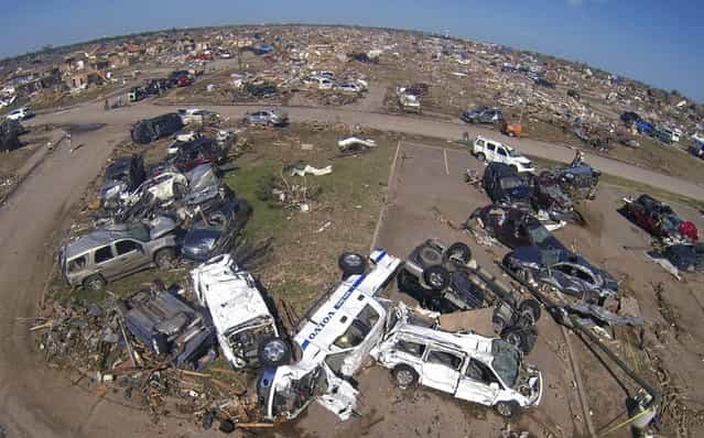 A pile of destroyed cars of teachers sits outside Briarwood elementary school in Oklahoma City, Oklahoma May 22, 2013. Rescue workers with sniffer dogs picked through the ruins on Wednesday to ensure no survivors remained buried after a deadly tornado left thousands homeless and trying to salvage what was left of their belongings. Curvature of horizon in the photo is due to an ultra-wide angle lens. (Photo by Rick Wilking/Reuters)