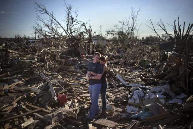 Danielle Stephan holds boyfriend Thomas Layton as they pause between salvaging through the remains of a family member's home one day after a tornado devastated the town Moore, Oklahoma, in the outskirts of Oklahoma City May 21, 2013. Rescuers went building to building in search of victims and thousands of survivors were homeless on Tuesday after a massive tornado tore through the Oklahoma City suburb of Moore, wiping out whole blocks of homes and killing at least 24 people. (Photo by Adrees Latif/Reuters)