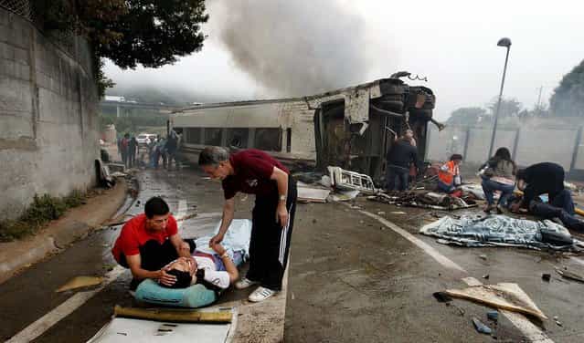 Victims receive help after a train crashed near Santiago de Compostela in Spain. At least 56 people died after the train derailed in the outskirts of the northern Spanish city, the head of Spain's Galicia region, Alberto Nunez Feijoo, told Television de Galicia. (Photo by Xoan A. Soler/Monica Ferreiros/La Voz de Galicia/Reuters)