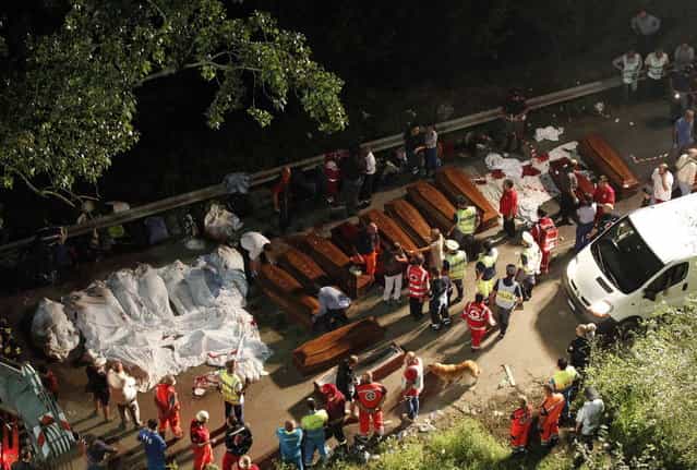 Bodies of victims are lined up after a coach crash near the southern town of Avellino July 29, 2013. At least 36 people died after the bus plunged more than 15 meters (49 feet) off a viaduct in southern Italy on Sunday, a spokesman for the fire service said. (Photo by Ciro De Luca/Reuters)