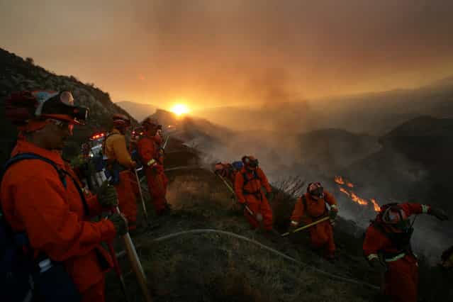 Hand crews work to put out hot spots that burn along Highway 74 in the Cleveland National Forest as the Falls Fire swept through the area on Monday, August 5, 2013. (Photo by Stan Lim/AP Photo/The Press-Enterprise)