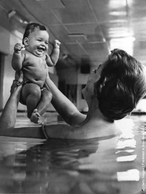 A mother teaching her 17-week old baby daughter to swim, 1966