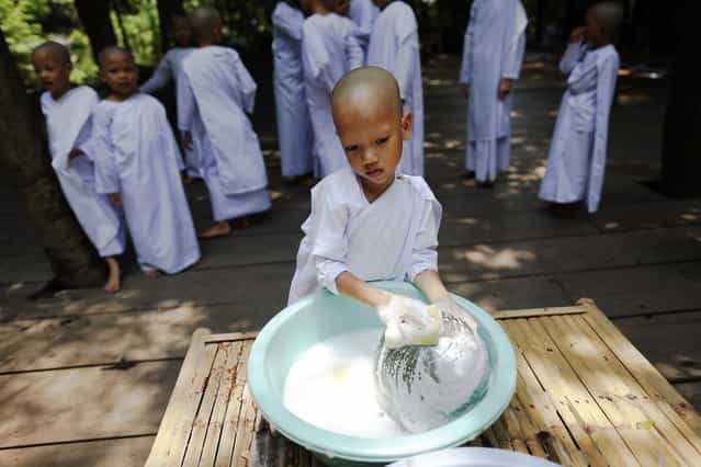 A novice nun washes her bowl after lunch at the Sathira-Dhammasathan Buddhist meditation centre in Bangkok April 21, 2013. A group of Thai girls are choosing to spend part of their school holidays as Buddhist nuns, down to having their heads shaven at the meditation centre. The centre, founded in 1987, is a learning community for peace and harmony that has programs open to people regardless of age and gender. (Photo by Damir Sagolj/Reuters)