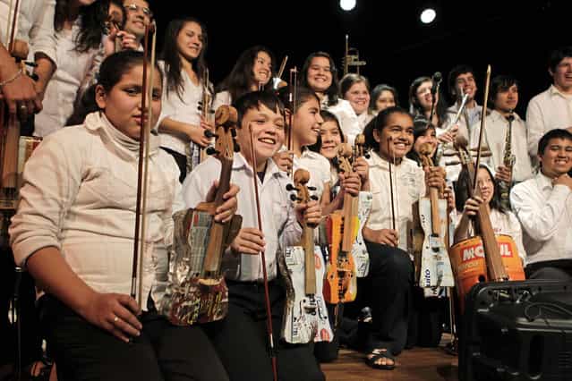 Members of the Orchestra of Recycled Instruments of Cateura pose for the audience during a concert in Asuncion, June 22, 2013. The orchestra is the brainchild of its conductor Favio Chavez, who wanted to help the children of garbage pickers at the local landfill, and the instruments are made from salvaged materials by craftsman Nicolas Gomez. The orchestra now involves 30 schoolchildren who have toured countries in Latin America, North America and Europe to play music ranging from Beethoven and Mozart to the Beatles and Paraguayan folk songs. (Photo by Jorge Adorno/Reuters)