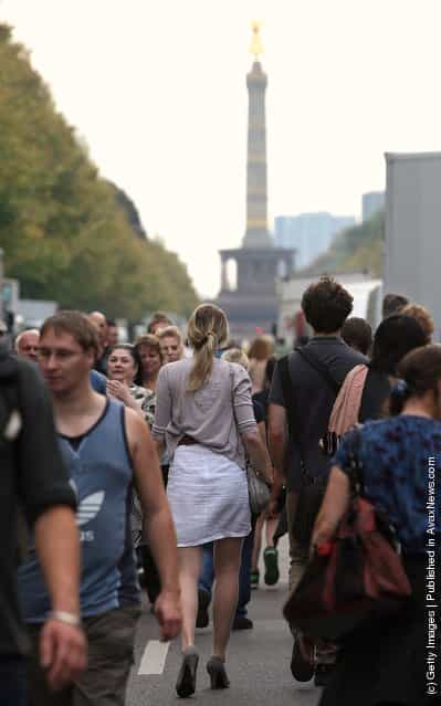 Visitors walk in front of the Siegesaeule (Victory Column) during an outdoor festival to celebrate German Unity Day