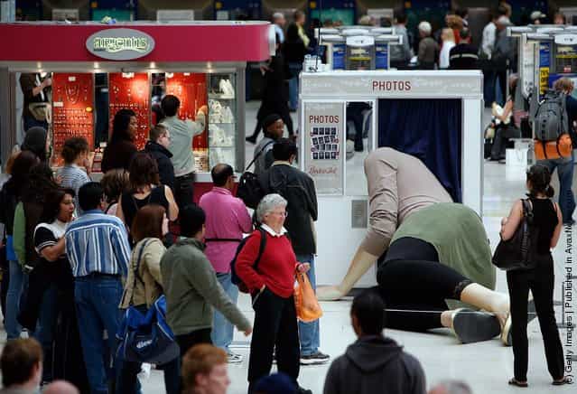 Sculpture of a giant lady with her head stuck in a photo booth