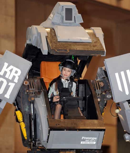 Female [pilot] Anna (C) looks out the cockpit of Japanese electronics company Suidobashi Heavy Industrys newly unveiled robot "Kuratas" at the Wonder Festival in Chiba, suburban Tokyo on July 29, 2012. The Kuratas robot, which will go on sale with a price tag of one million USD, measures four meters in height, weighs four tons and has four wheeled legs that can either be controlled remotely through the 3G network or by a human seated within the cockpit.
