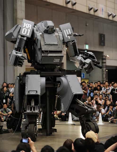 Japanese electronics company Suidobashi Heavy Industry unveils its latest robot [Kuratas] (C) as a crowd of people take photographs at the Wonder Festival in Chiba, suburban Tokyo on July 29, 2012. The Kuratas robot, which will go on sale with a price tag of one million USD, measures four meters in height, weighs four tons and has four wheeled legs that can either be controlled remotely through the 3G network or by a human seated within the cockpit.