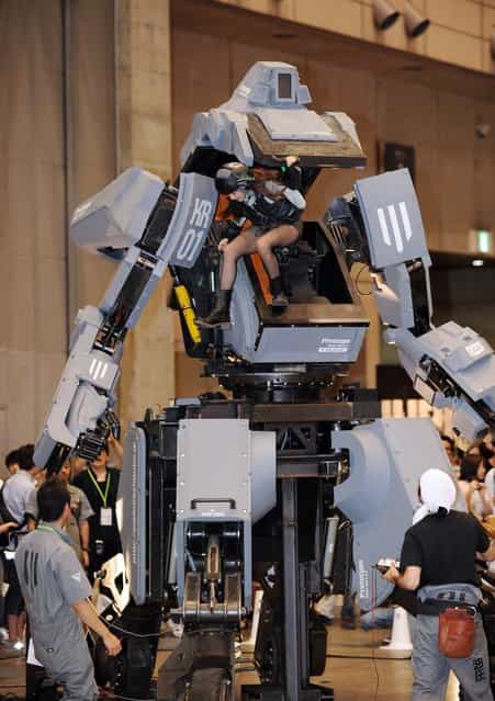 Female [pilot] Anna (C) climbs out the cockpit of Japanese electronics company Suidobashi Heavy Industrys newly unveiled robot [Kuratas] at the Wonder Festival in Chiba, suburban Tokyo on July 29, 2012. The Kuratas robot, which will go on sale with a price tag of one million USD, measures four meters in height, weighs four tons and has four wheeled legs that can either be controlled remotely through the 3G network or by a human seated within the cockpit.
