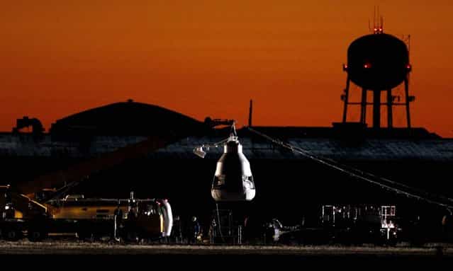 As the sun rises on Sunday, October 14, workers prepare at the launch site for the rescheduled mission. (Photo by Ross D. Franklin/Associated Press)