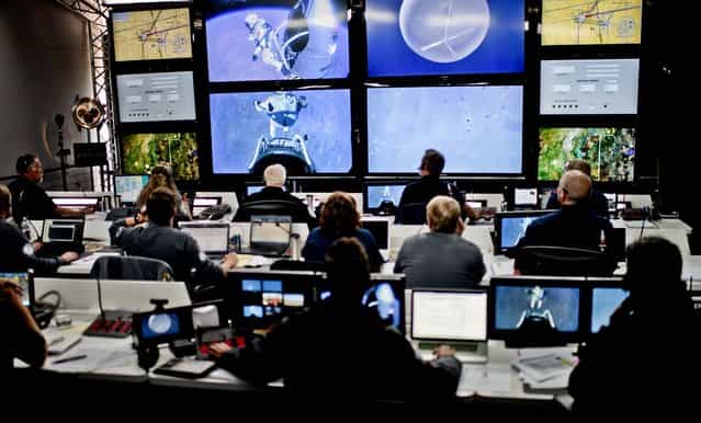 Crew members at mission control watch the jump. (Photo by Joerg Mitter/Red Bull)