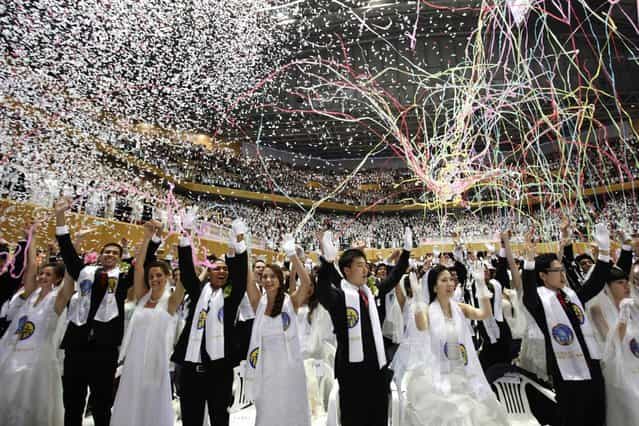 Newlyweds celebrate during a mass wedding ceremony of the Unification Church at Cheongshim Peace World Centre in Gapyeong, about 60 km (37 miles) northeast of Seoul February 17, 2013. The Unification Church founded by evangelist reverend Moon Sun-myung in Seoul in 1954, performed its first mass wedding in 1961 with 33 couples. Approximately 3,500 couples attended the mass wedding on Sunday. (Photo by Kim Hong-Ji/Reuters)