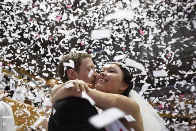 A newlywed couple celebrates during a mass wedding ceremony of the Unification Church at Cheongshim Peace World Centre in Gapyeong, about 60 km (37 miles) northeast of Seoul February 17, 2013. The Unification Church founded by evangelist reverend Moon Sun-myung in Seoul in 1954, performed its first mass wedding in 1961 with 33 couples. Approximately 3,500 couples attended the mass wedding on Sunday. (Photo by Kim Hong-Ji/Reuters)