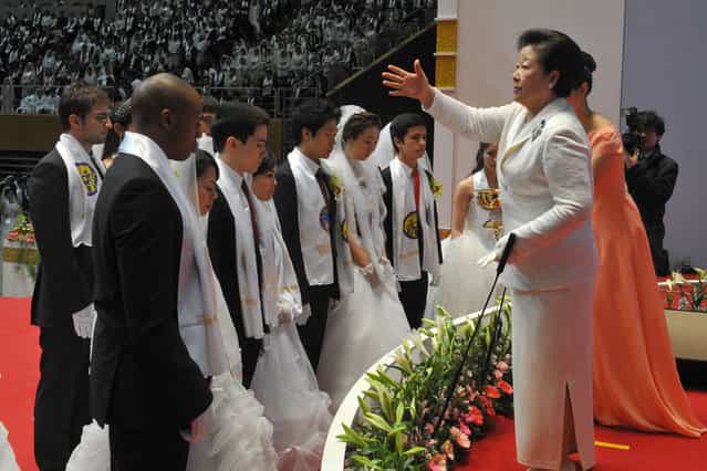 Hak Ja Han Moon (R), the widow of the late Unification Church founder Sun Myung Moon, sprinkles the church's holy water onto newly-married couples during the church's mass wedding that took place in its headquarters in Gapyeong, east of Seoul, on February 17, 2013. The Unification Church, set up by Sun Myung Moon in Seoul in 1954, is one of the world's most controversial religious organisations, and its devotees are often dubbed [Moonies] after the founder. (Photo by Kim Jae-Hwan/AFP Photo)