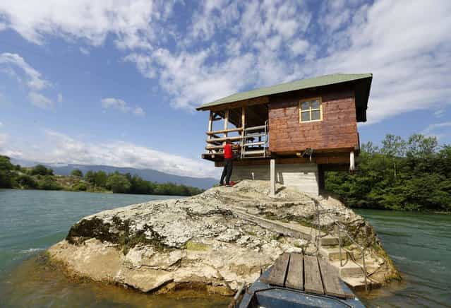 A man enters a house built on a rock on the river Drina near the western Serbian town of Bajina Basta, about 160km (99 miles) from the capital Belgrade May 22, 2013. (Photo by Marko Djurica/Reuters)