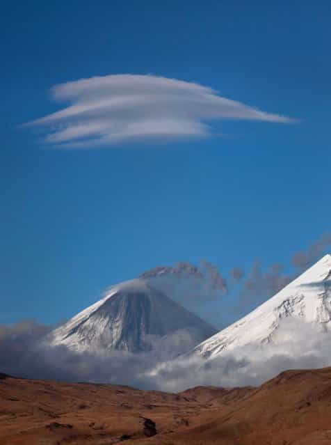 Lenticular clouds hover of the mountains of the Kamchatka Peninsula in Russia. (Photo by Denis Budkov/Caters News)