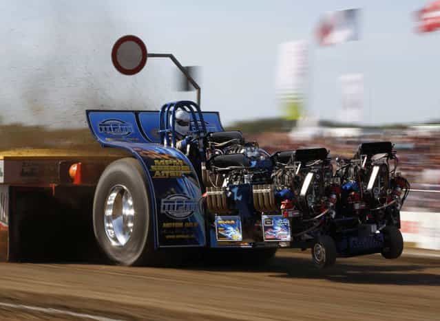 A driver competes in his tractor during the Tractor Pulling Euro Championships in the western German town of Fuechtorf September 9, 2012. Eighty teams from across Europe participated in the two-day competition where high-powered tractor prototypes must pull a trailer down a 100-metre (328 ft) track as far as possible. (Photo by Ina Fassbender/Reuters)