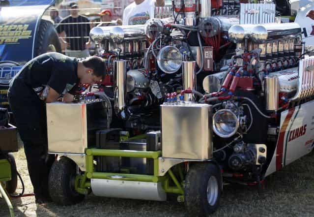 A mechanic checks a tractor motor during the Tractor Pulling Euro Championships in the western German town of Fuechtorf September 9, 2012. Eighty teams from across Europe participated in the two-day competition where high-powered tractor prototypes must pull a trailer down a 100-metre (328 ft) track as far as possible. (Photo by Ina Fassbender/Reuters)
