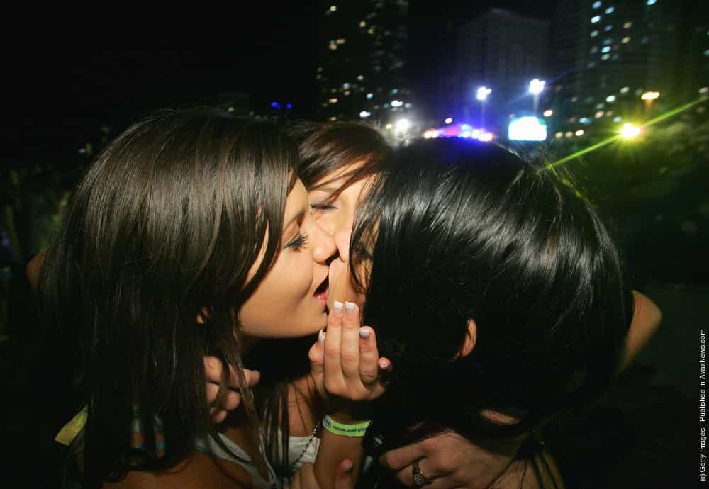 A group of graduating year 12 students kiss on the beach front during the o...